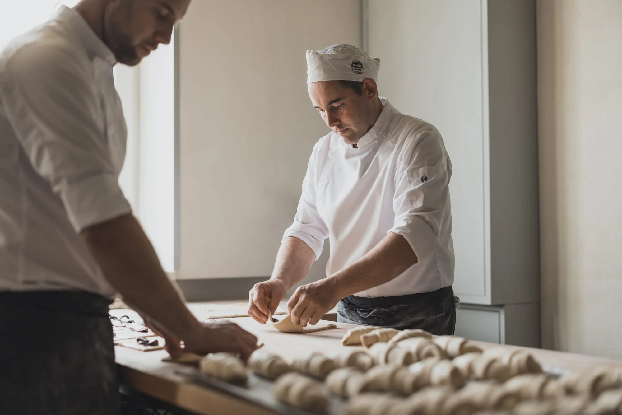 Hände formen Croissants auf der Arbeitsfläche