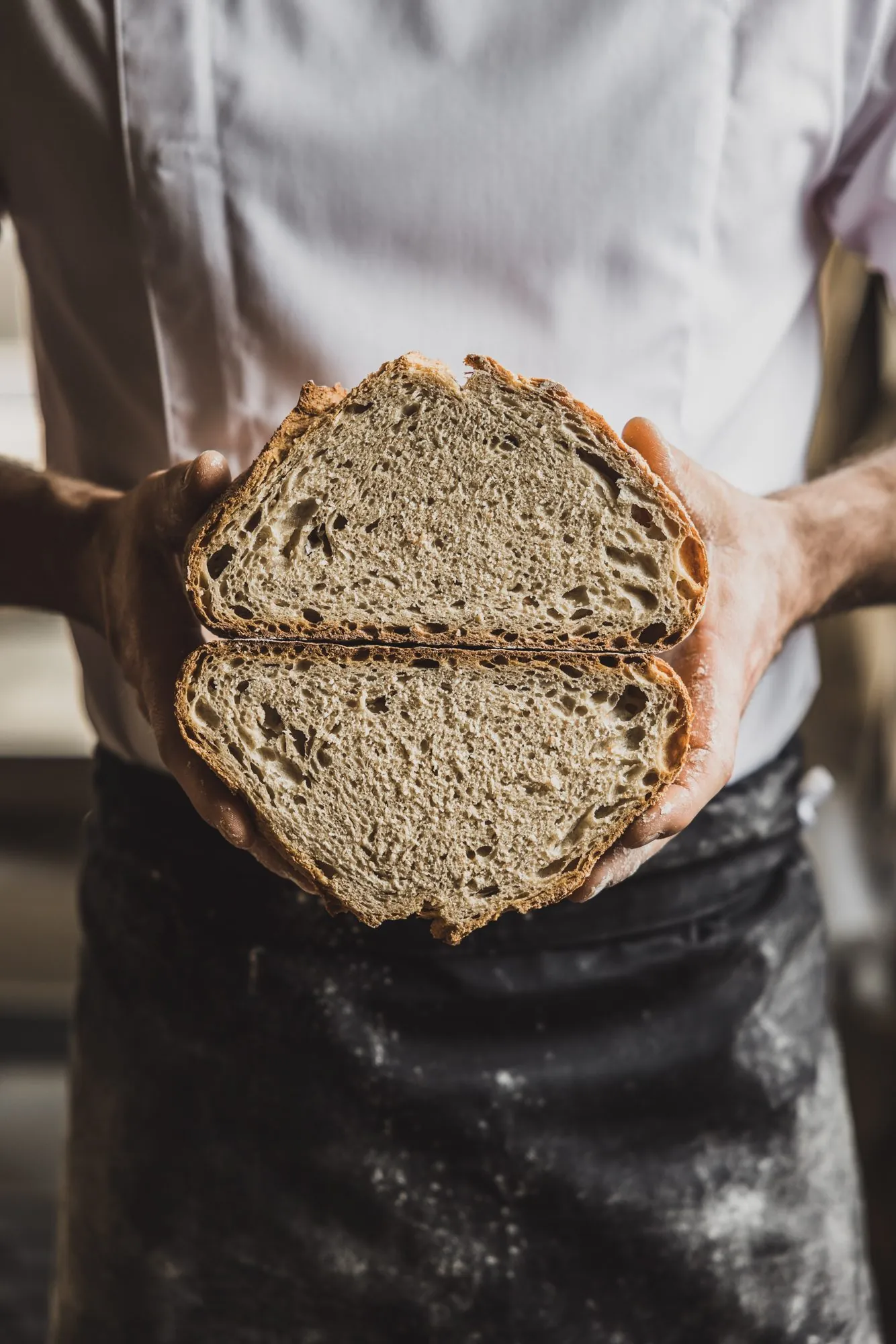 Aufgeschnittenes Brot in den Händen eines Bäckers