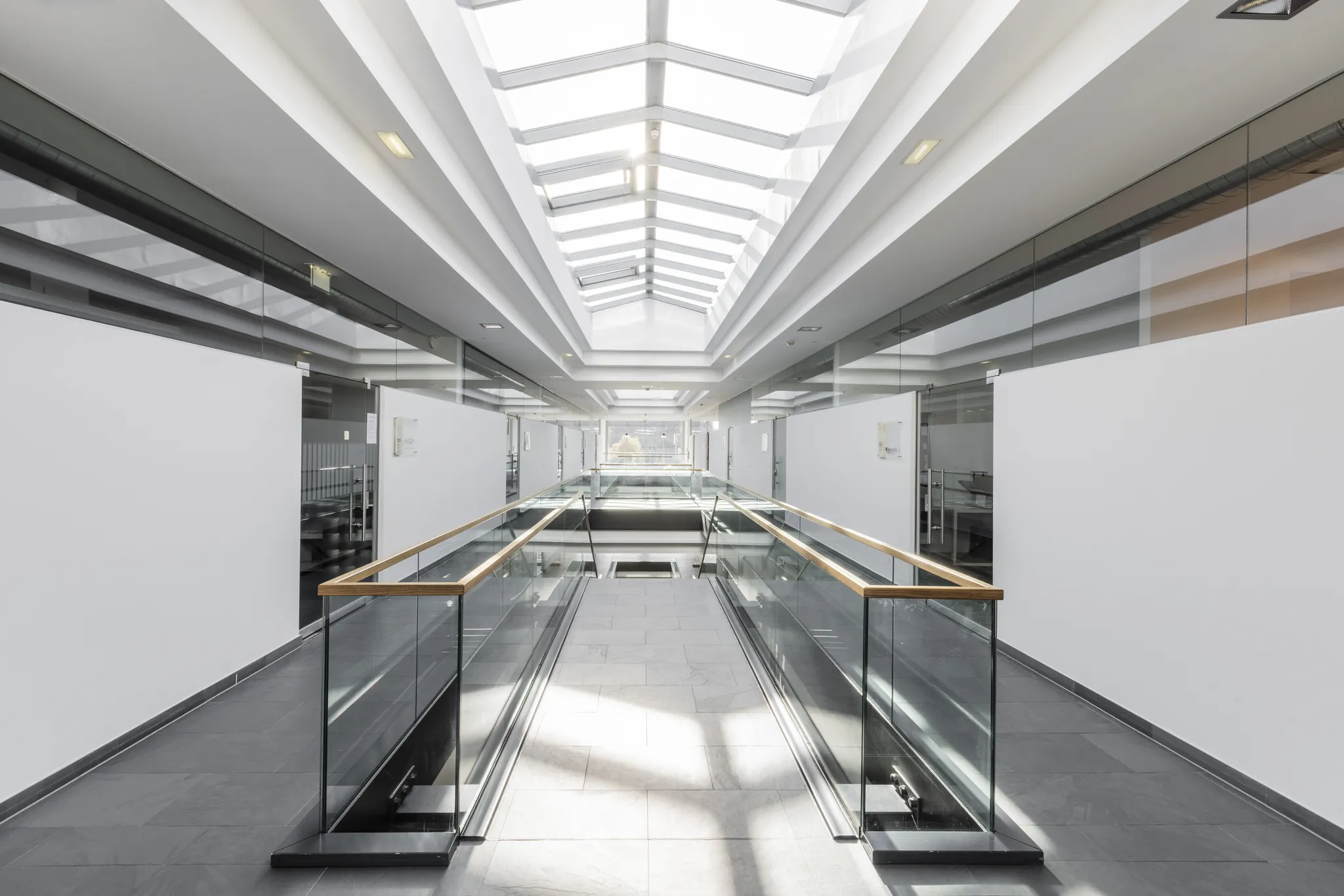 Galerie mit Holzhandlauf unter dem Glasdach des Fashionpalais