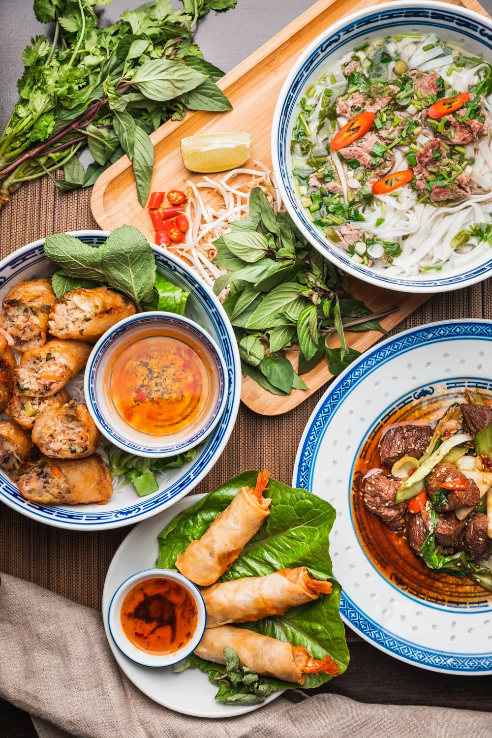 Vietnamesische Gerichte mit Kräutern und Frühlingsrollen von oben, An Nam