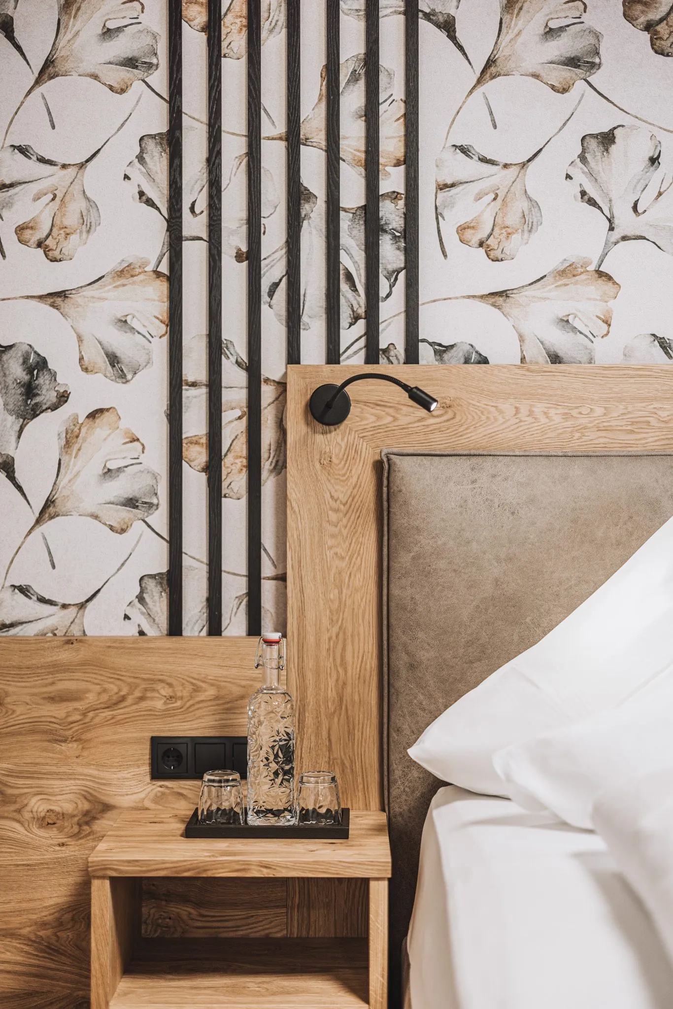 Detail eines Zimmers mit Ginkgo-Tapete und Holzbett, Hotel Gaspingerhof
