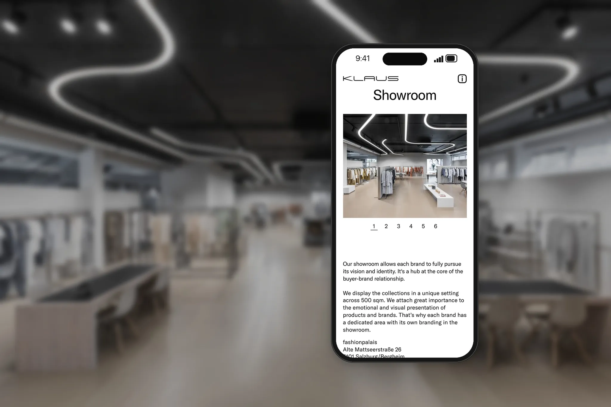 Smartphone mit der Showroom-Seite der Modeagentur KLAUS vor dem echten Showroom