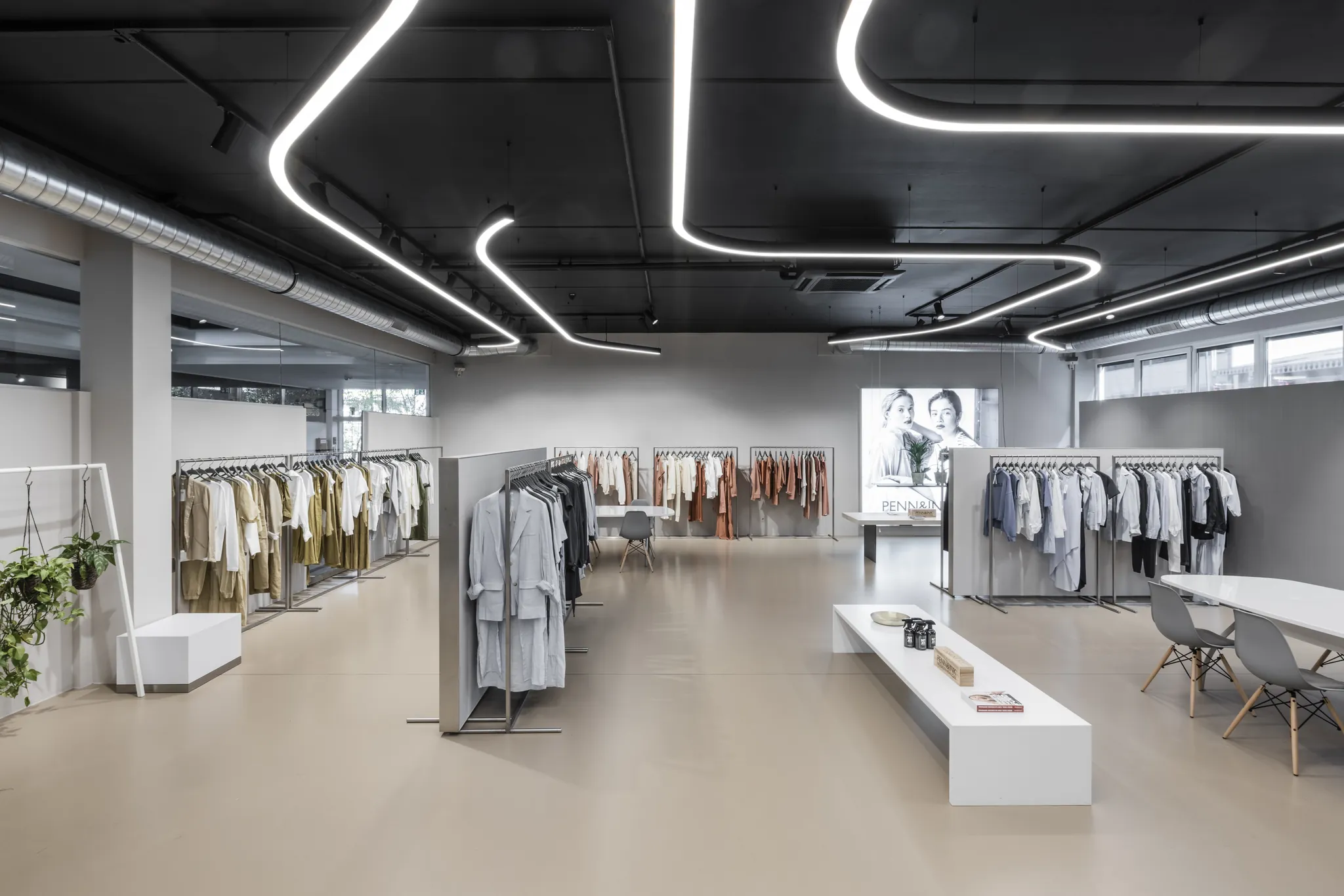 Kollektionen auf Kleiderstangen unter der LED-Decke im Showroom der Modeagentur KLAUS