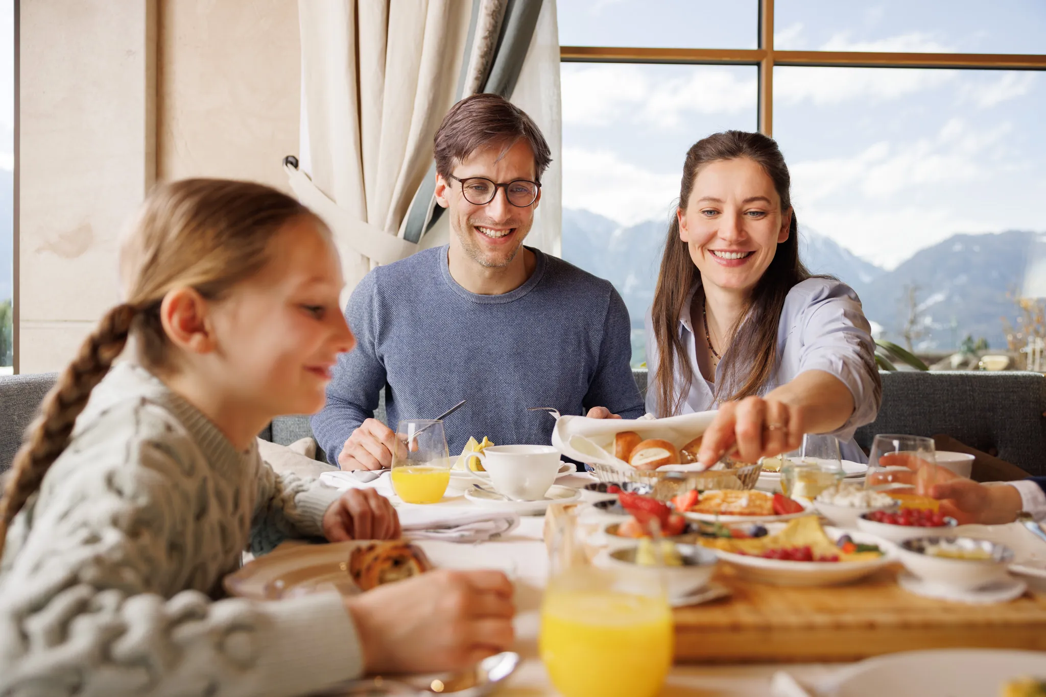 Familie frühstückt am Fenster mit Blick auf die Berge, Wellnessresidenz Schalber