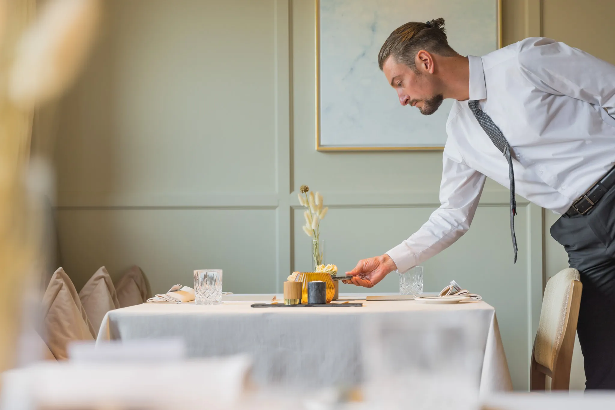 Kellner serviert am weiß eingedeckten Tisch, Hotel Sonnenburg