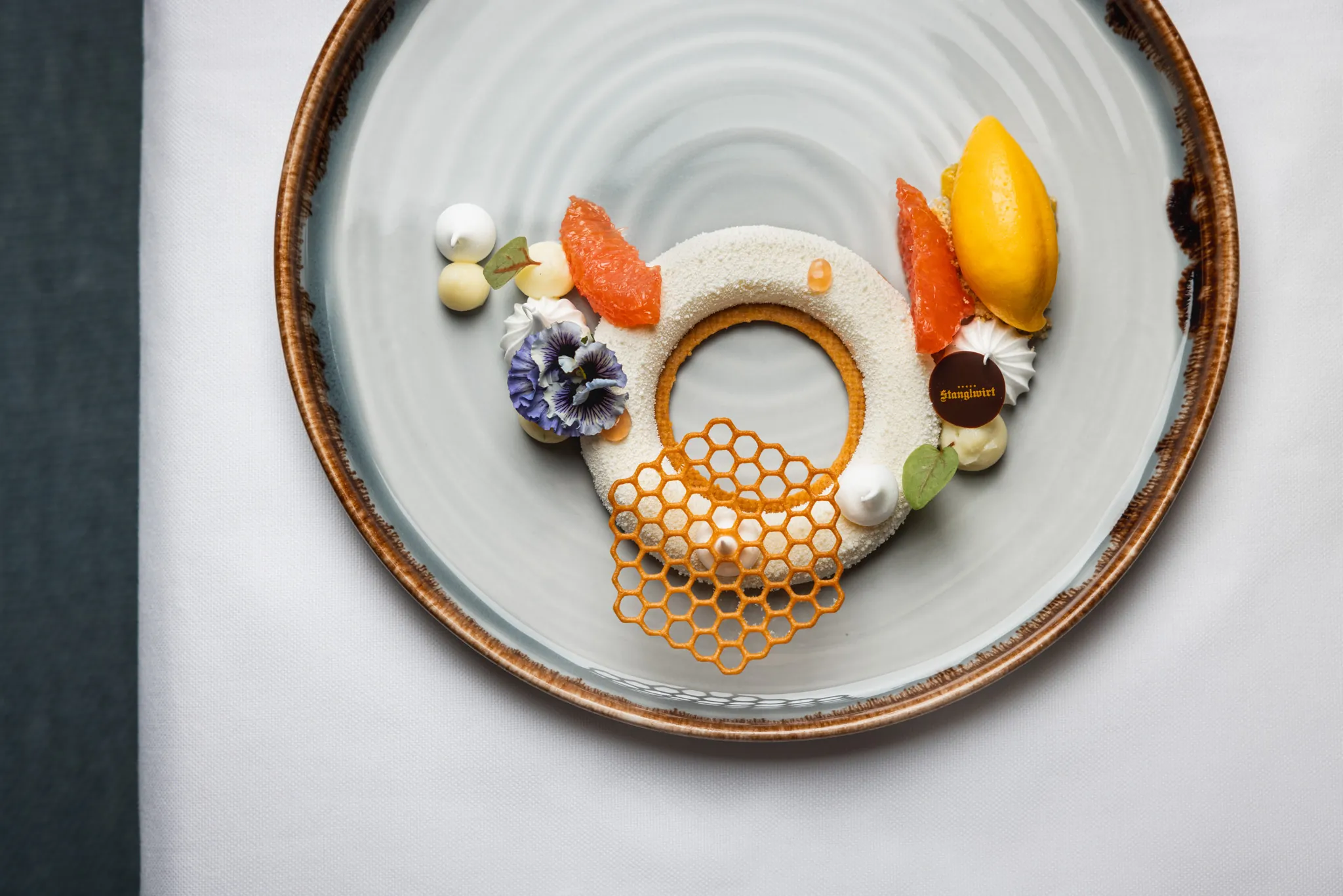 Kunstvoll angerichteter Dessertteller mit Wabenmuster von oben, Stanglwirt